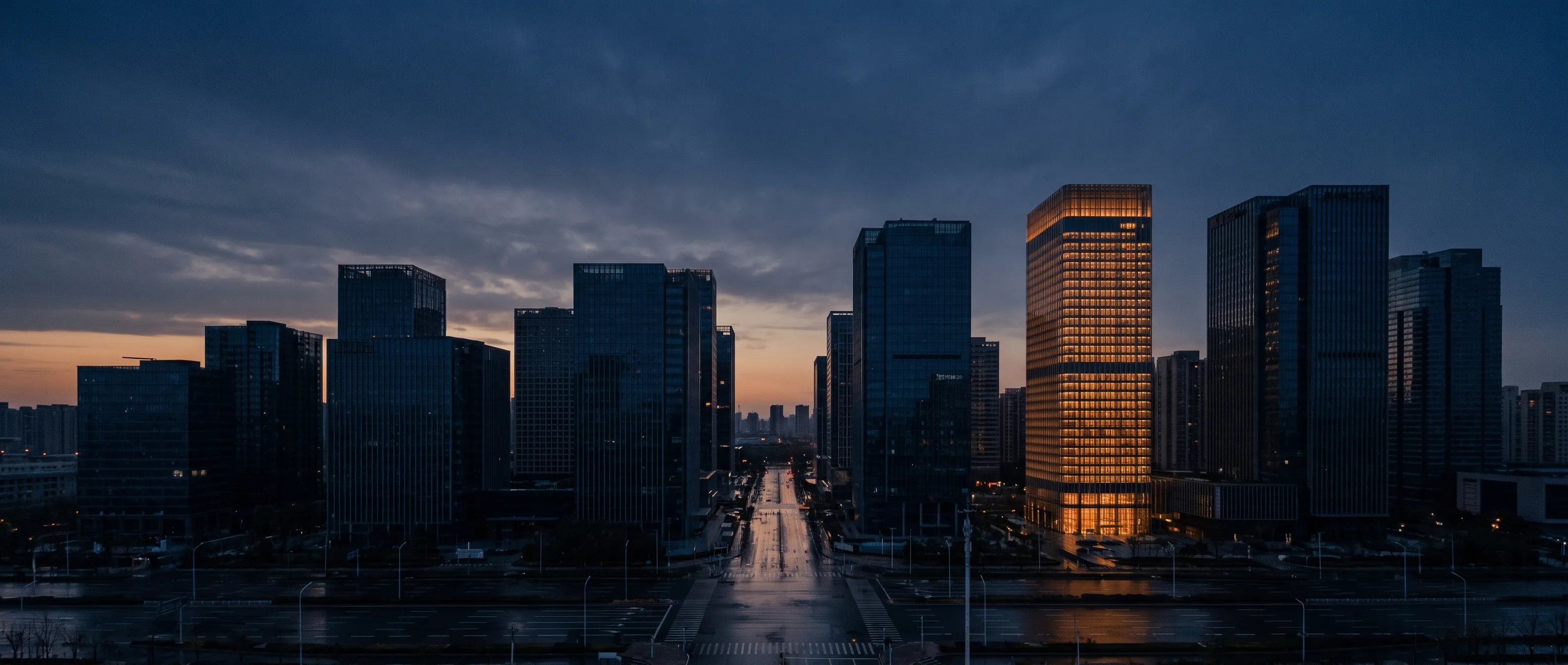 City towers at dusk, office floors lit from within.